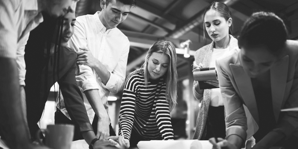 Skills to work differently - team collaboration at a meeting room table to solve a problem